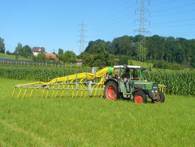 Traktor mit Schleppschlauchsystem beim Gülle ausbringen