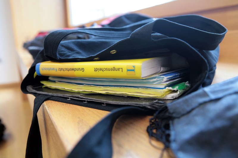 Offene Schulmappe mit Büchern